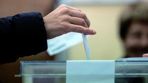 Un elector deposita su voto en una urna.