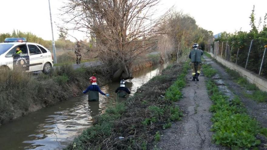 Bomberos buscando el cuerpo, ayer en la acequia.