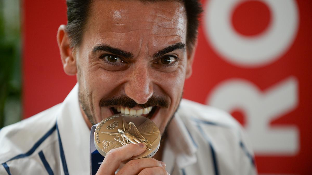 Damián Quintero muerde su medalla de plata lograda en Tokio 2020.