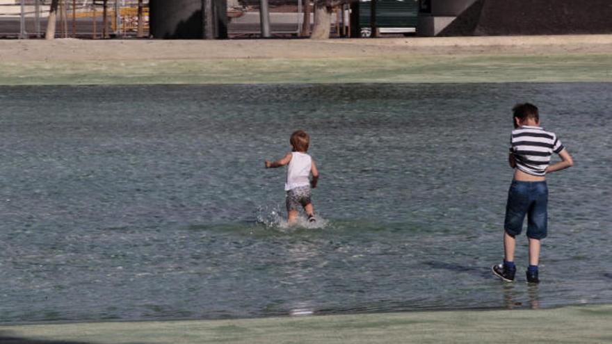 Los más pequeños se lanzaron a chapotear en el lago de la plaza de España para sofocar el intenso calor.