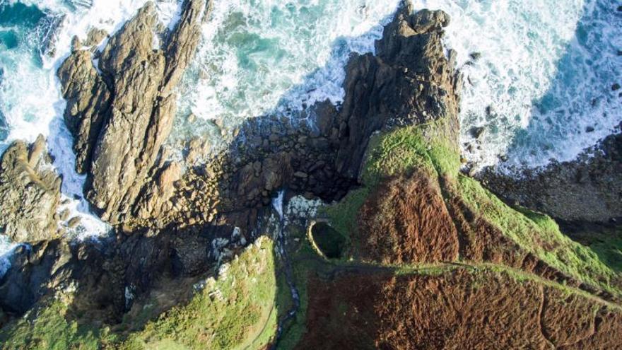 Molino de Augacae (Arteixo). De este molino de río solo queda en pie parte de la estructura principal. . Situado en el borde del acantilado, aprovechaba para su funcionamiento el agua del río que desciende, precipitándose directamente al mar en forma de cascada.  | DAVID GARCÍA-LOUZAO