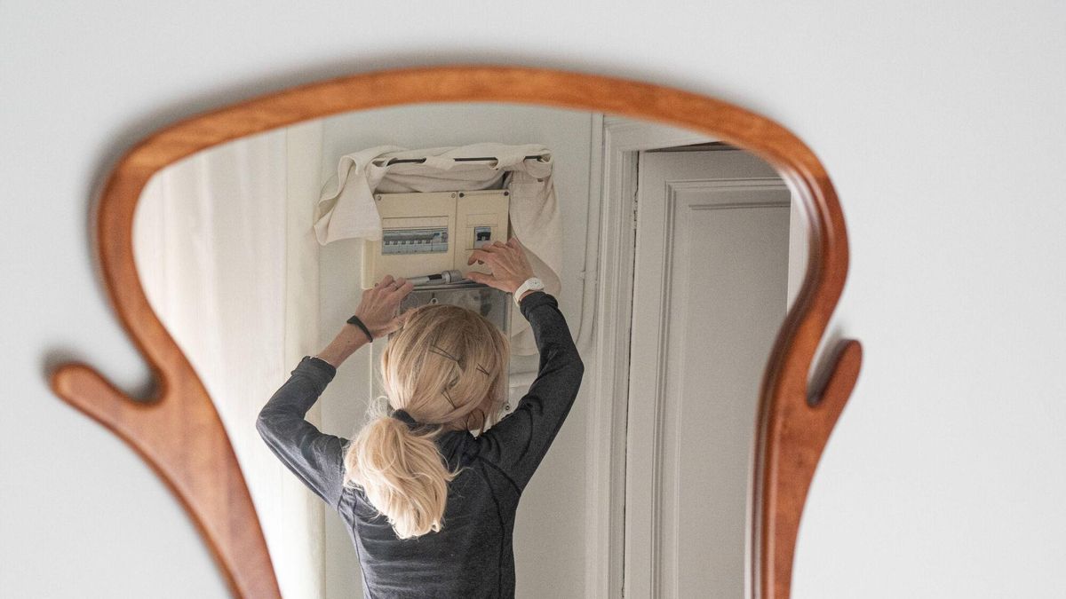 Una mujer interactúa con el cuadro eléctrico de su hogar