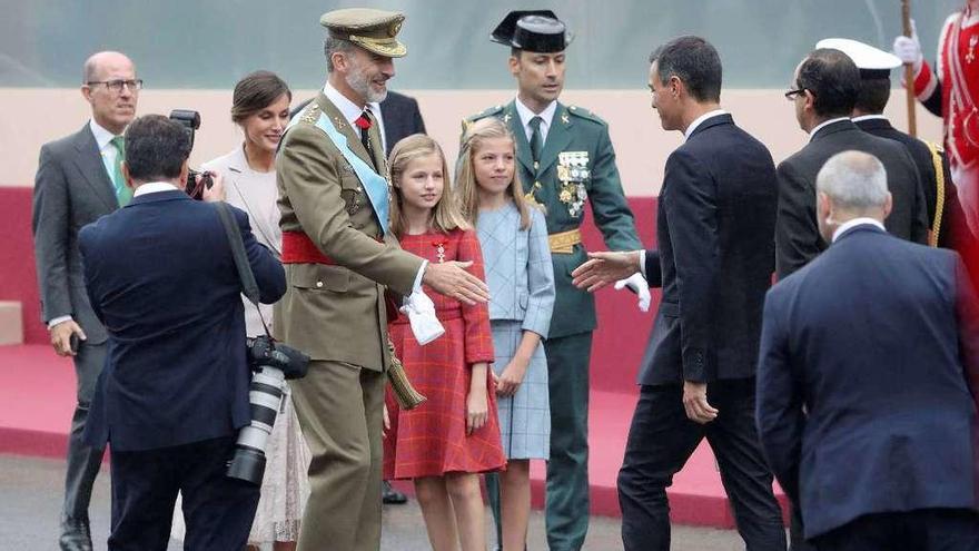 El Rey y Pedro Sánchez se saludan antes del comienzo del desfile militar. // Efe