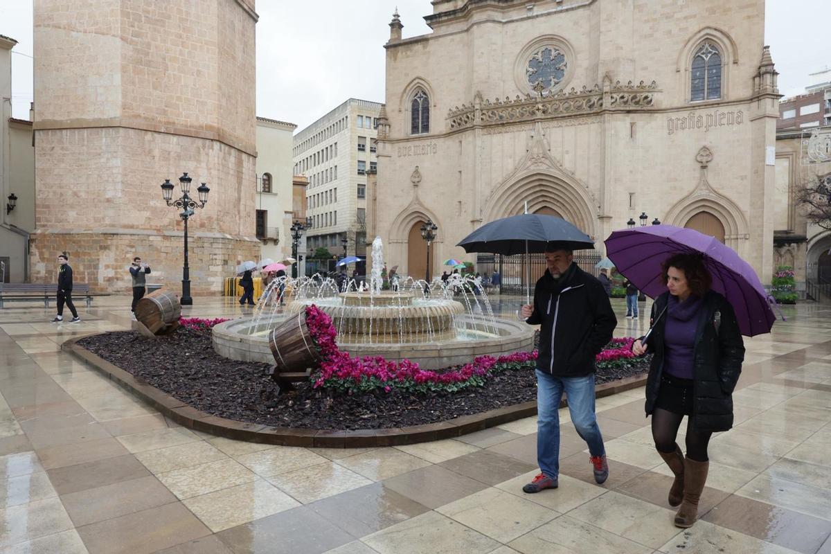 Dos vecinos se resguardan con un paraguas de la lluvia que cayó ayer en Castelló.