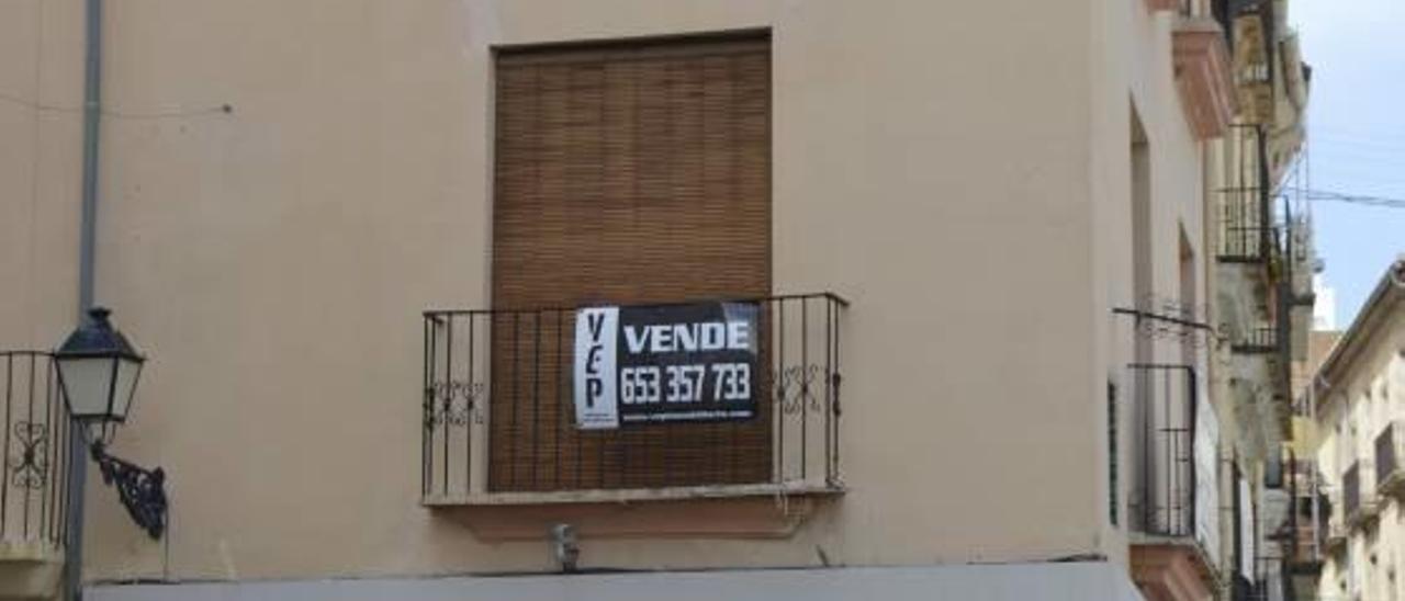 Un cartel indica que una vivienda, ubicada en plena plaza Major de Gandia, está en venta.