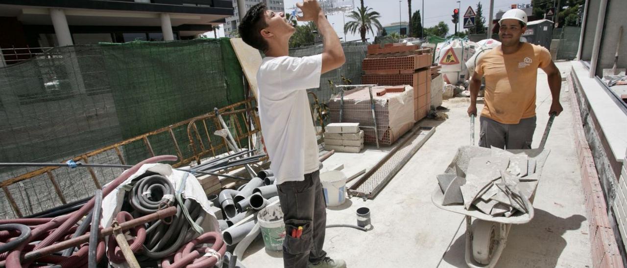 Un empleado de la construcción bebe agua para hidratarse, ayer. | JUAN CARLOS CAVAL