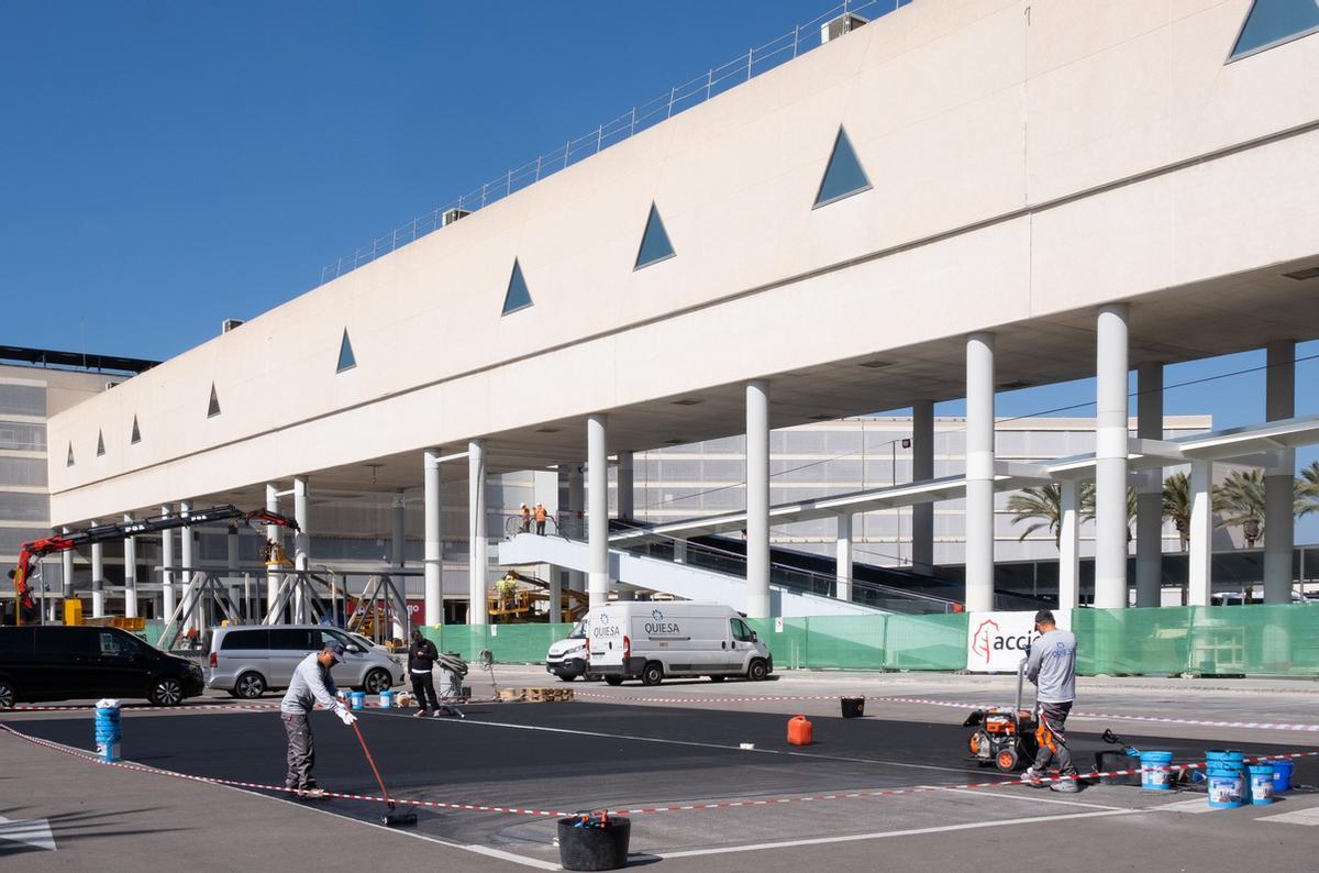 Obras en la pasarela elevada mientra unos operarios reasfaltan, ayer miércoles, el aparcamiento de vehículos VTZ