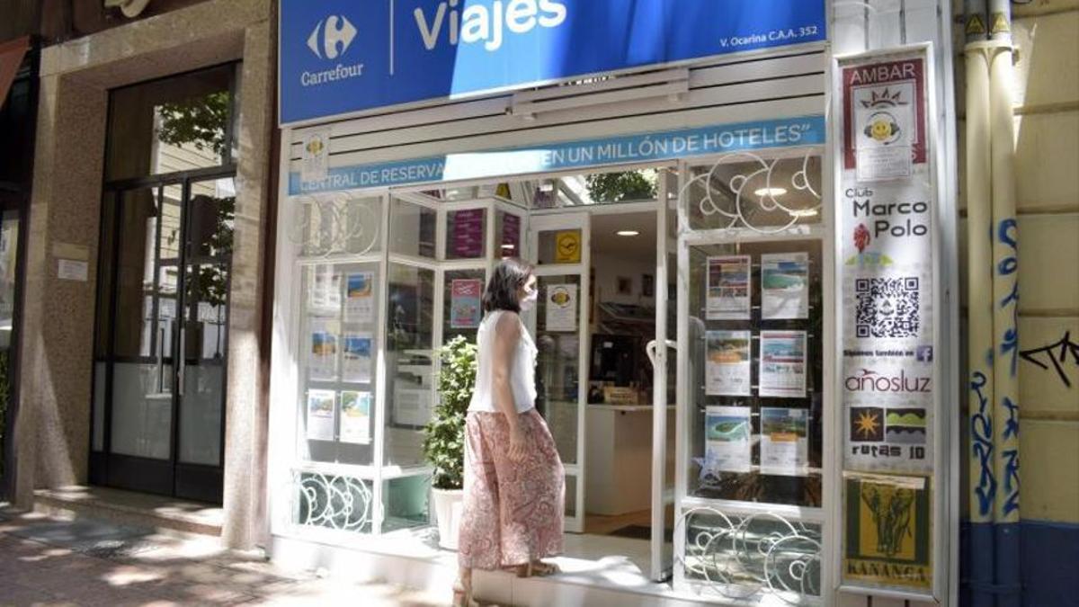 Una mujer entra a un establecimiento de una agencia de viajes de la ciudad de Zaragoza.