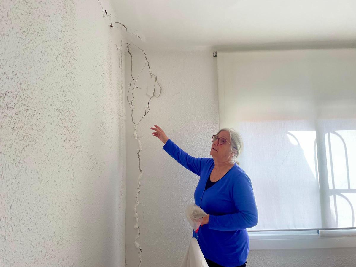 Lola Sánchez, vecina de la calle Besós en el barrio de Can Sant Joan, Montcada i Reixac, muestra las grietas aparecidas en su vivienda tras las obras de soterramiento.