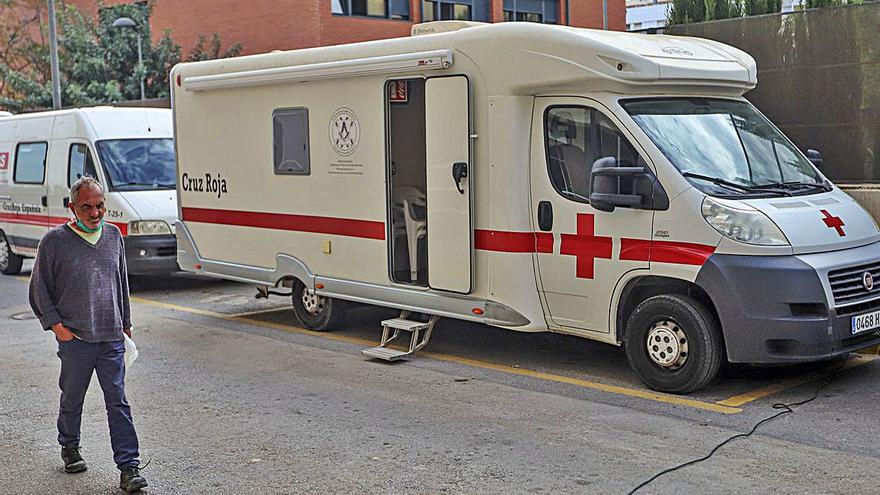 Una persona sin hogar, tras salir de la autocaravana aparcada en una calle de Callosa de Segura, que cuenta con duchas que a punto está de usar otro sintecho. | TONY SEVILLA