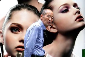 Un home passeja davant un anunci de cosmètics a Tòquio, Japó.