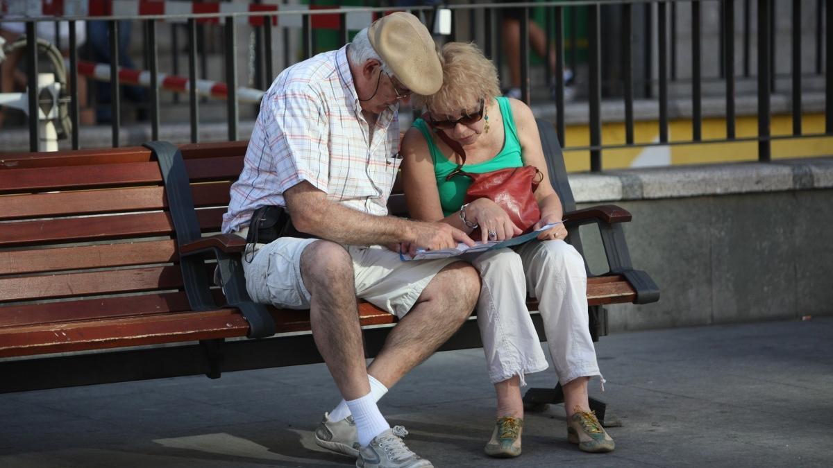 Dos pensionistas, sentados en un banco.