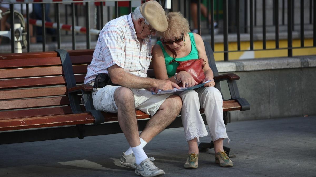 Dos pensionistas, sentados en un banco.