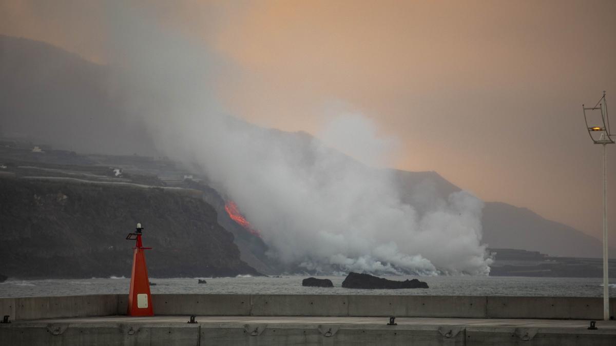 Columna de humo y lava del volcán de Cumbre Vieja a su llegada al mar en la costa del municipio de Tazacorte.