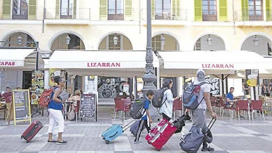 Un grupo de turistas en la plaza Major de Palma este verano.