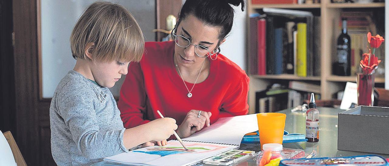 Una madre trabajadora ayuda a su hijo a realizar las tareas escolares.