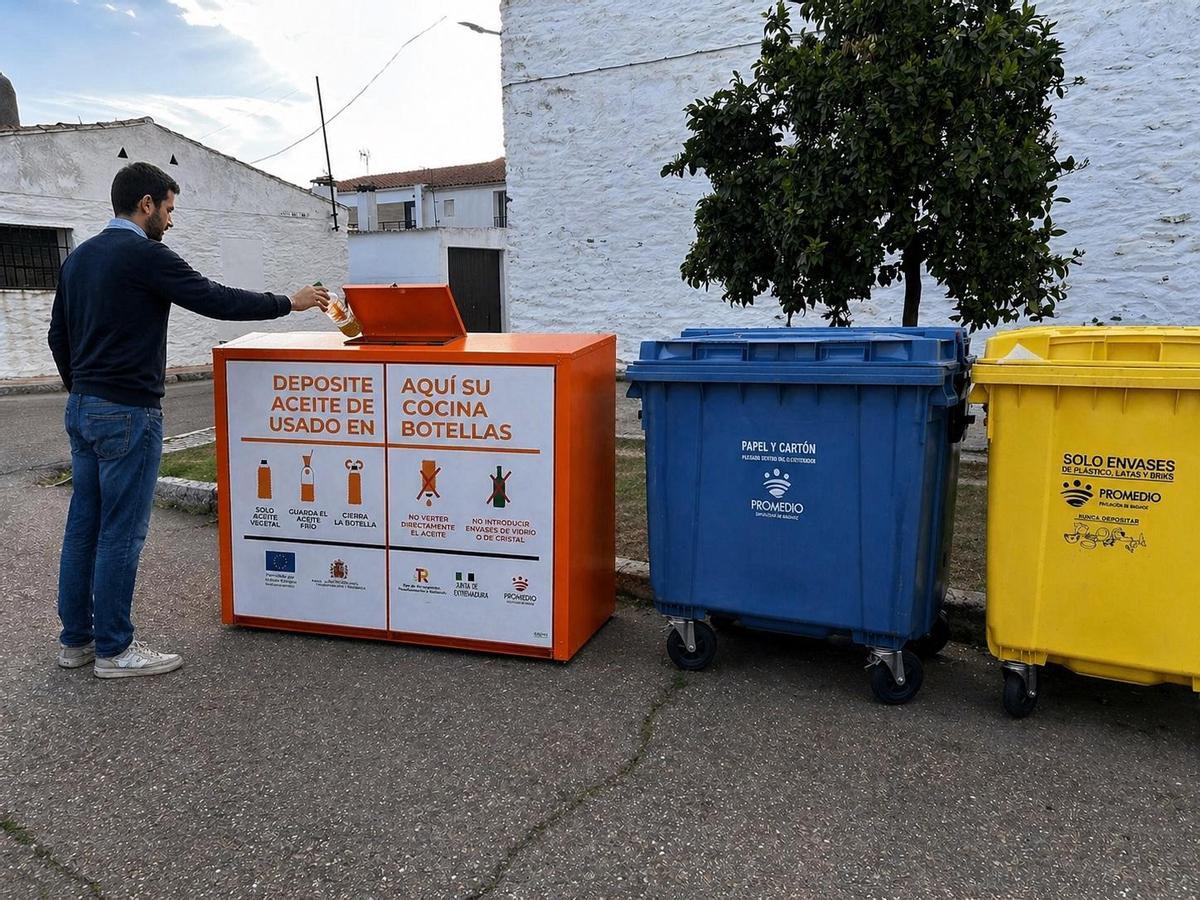 Persona reclica aceite usado de cocina en un contenedor naranja.
