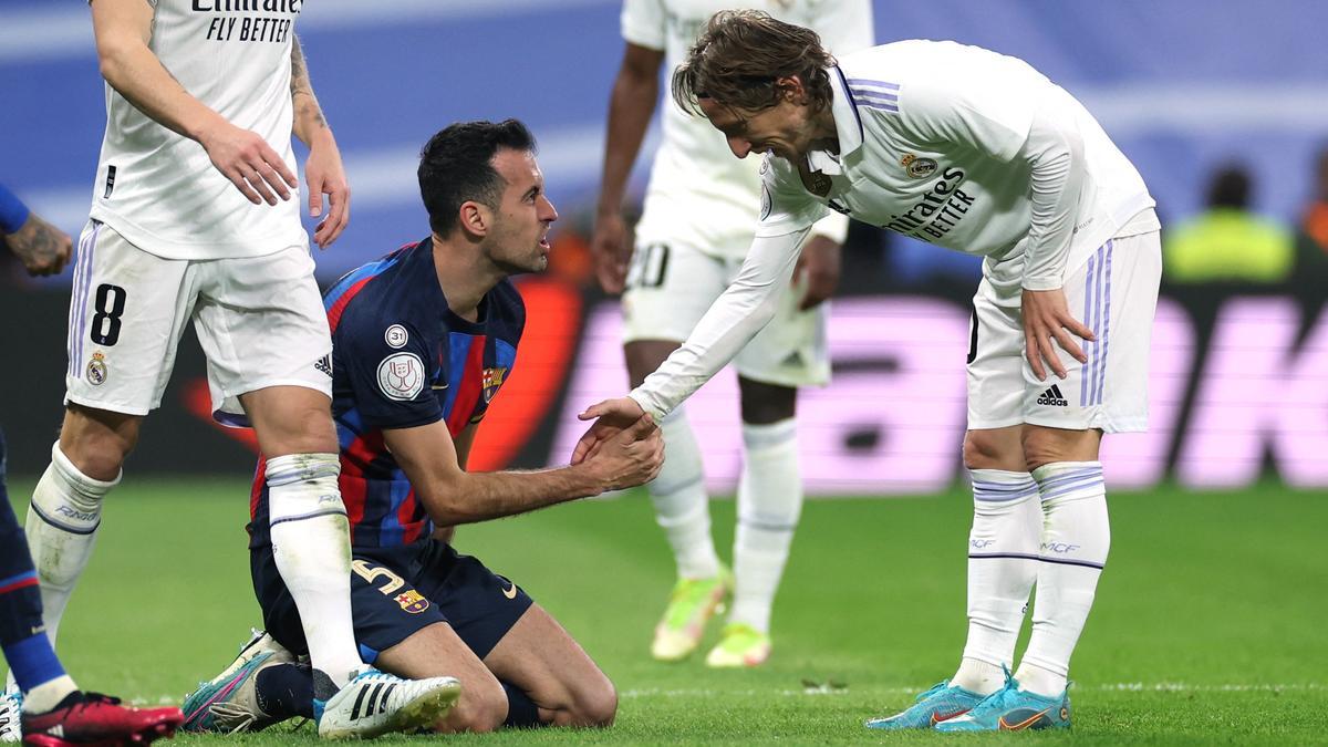 Modric ayuda a levantarse a Busquets tras sufrir una falta en el clásico copero del Bernabéu.