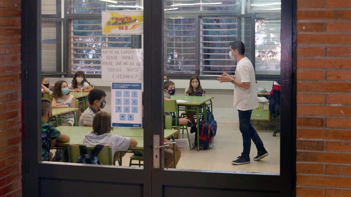 GRAFCAT1358  BARCELONA  14 09 2020 - Un profesor da la bienvenida a sus alumnos en la Escola Catalonia de Barcelona este lunes  cuando un millon y medio de alumnos catalanes vuelven a las escuelas e institutos en un inicio de curso marcado por la COVID-19  que impedira los abrazos de reencuentro y obligara a los estudiantes a acceder a las aulas de forma escalonada  con mascarilla  las manos lavadas y la temperatura tomada  EFE Enric Fontcuberta