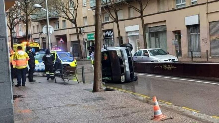 Un cotxe bolca en pujar a sobre la mitjana del carrer del Carme de Girona