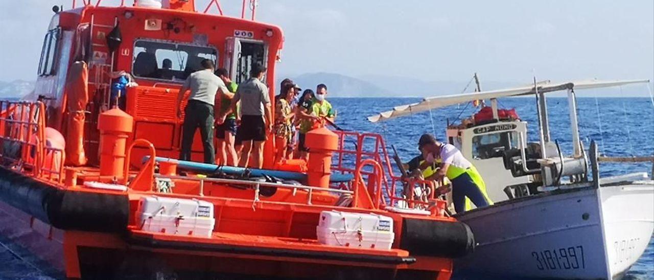 Momento en el que la embarcación de Salvamento Marítimo sube a los rescatados a bordo.