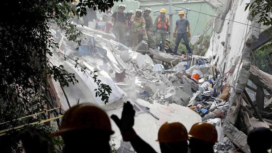 Los bomberos mexicanos buscan supervivientes en uno de los edificios derrumbados.