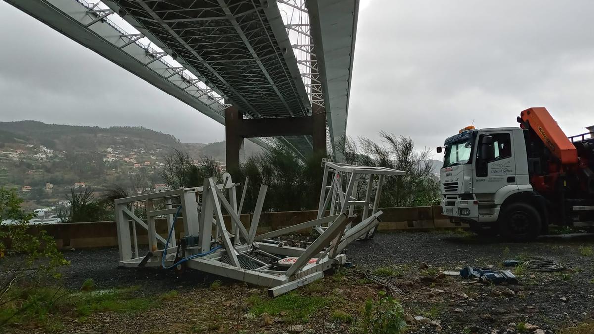 Los operarios retiran los restos del montacargas precipitados desde el puente de Rande