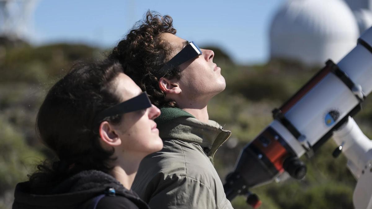Imagen de archivo de un grupo de personas mientras observa un eclipse parcial de sol desde el Observatorio del Teide