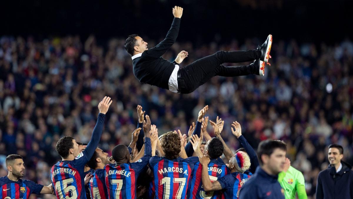 Xavi, manteado por los jugadores del Barça