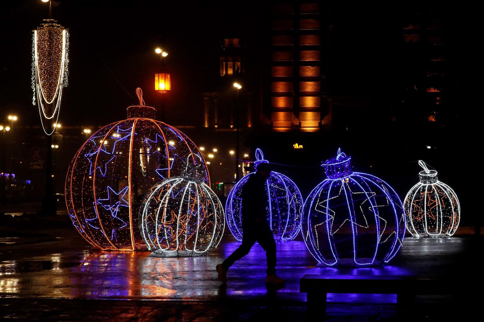 San Petersburgo (Federación de Rusia), 16/12/2021.- La gente camina en el prospecto Moskovsky, decorado estacionalmente para Navidad y Año Nuevo durante una tarde lluviosa en San Petersburgo, Rusia, 16 de diciembre de 2021. La temperatura invernal alcanzó los tres grados centígrados. en la segunda capital de Rusia. (Rusia, San Petersburgo)