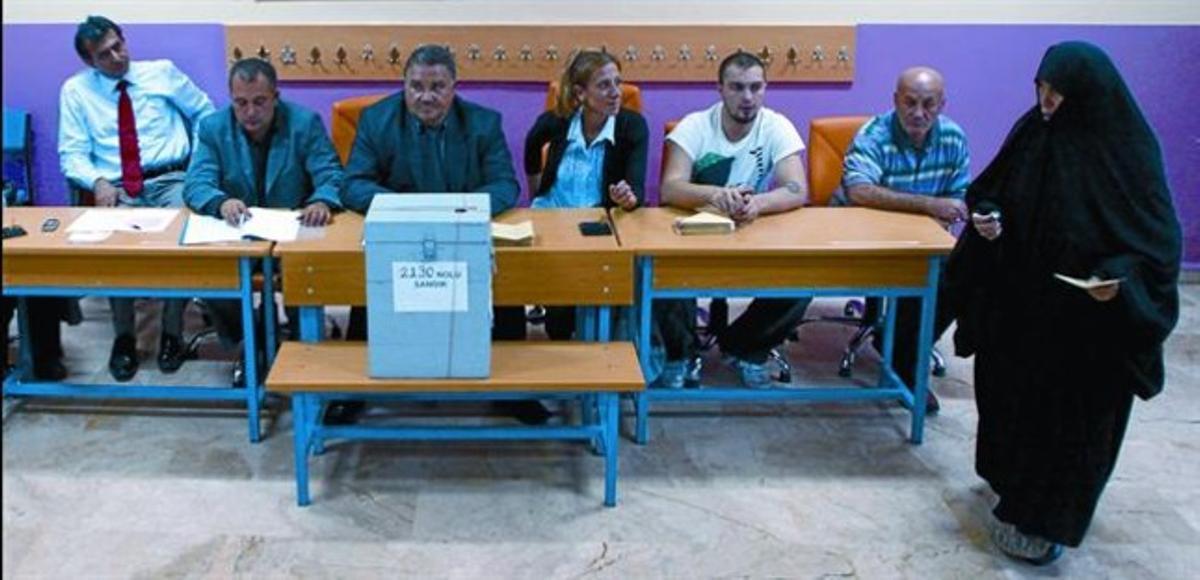 Una dona es disposa a votar en un col·legi electoral d’Istanbul,  diumenge.