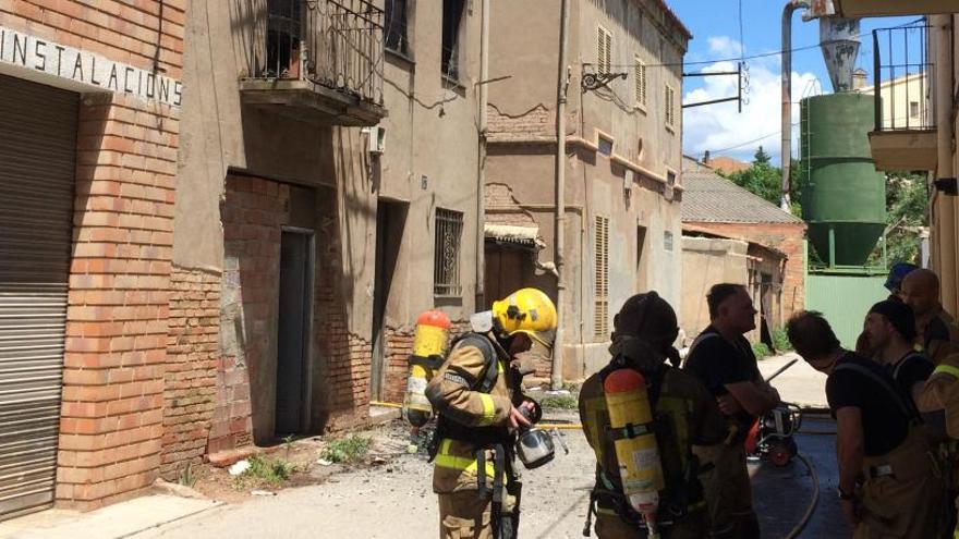 Els Bombers, ahir al migdia davant de la casa cremada per l&#039;incendi.