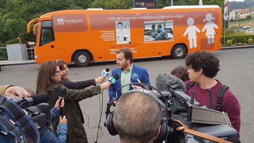 El portavoz de Hazte Oír, Pablo Santana, responde a los medios con el bus detrás, ayer en Santiago. // FdV