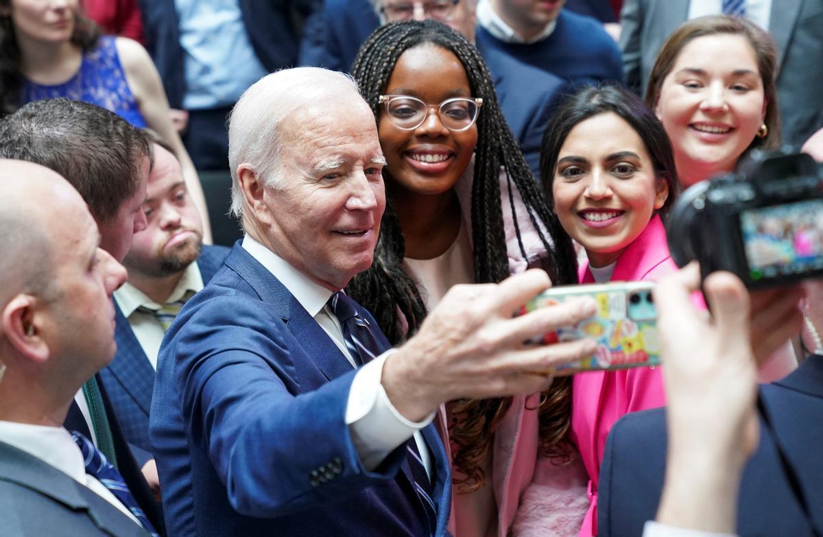 El presidente de los Estados Unidos, Joe Biden, se toma una selfie con estudiantes en el 25 aniversario del Acuerdo de Belfast/Viernes Santo, en la Universidad de Ulster, Belfast.