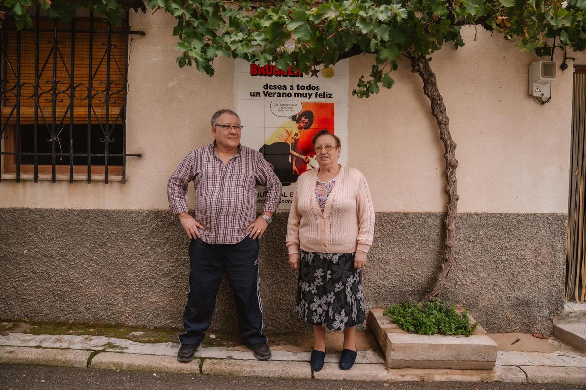 Dos vecinos de Olmeda de la Cuesta, junto al anuncio de pinturas de Johann Cruyff.