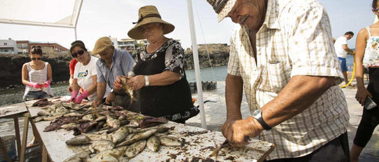 Cela y Pedro durante el jareado del pescado en el muellito.