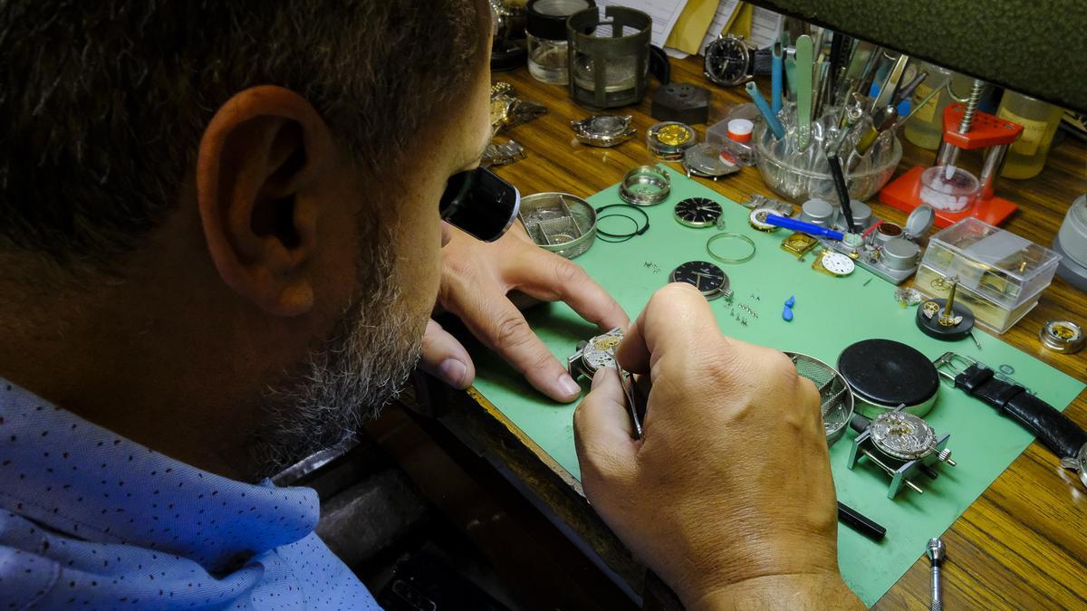 El relojero Oliver Casañas repara una pieza en el taller de la tienda que regenta desde hace una década.