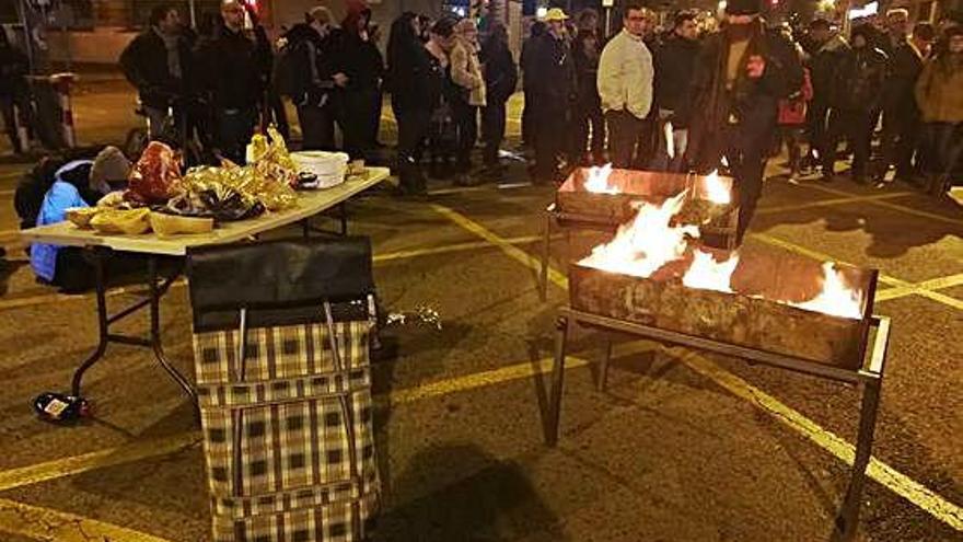 Manifestants preparant una barbacoa en el tall del carrer Barcelona