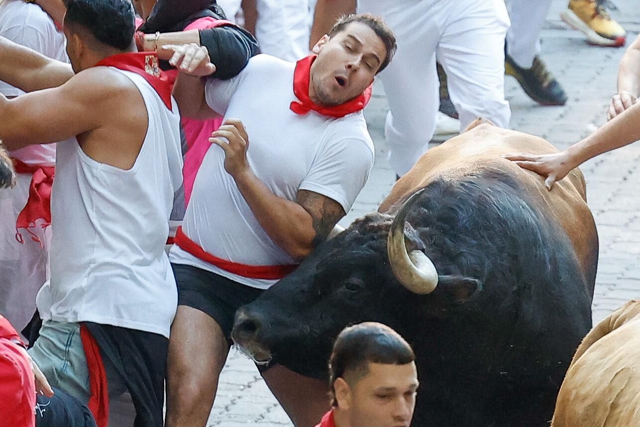 PAMPLONA, 09/07/2025.- Un mozo es corneado por uno de los toros de la ganadería Álvaro Núñez durante el tercer encierro de los Sanfermines 2025 este miércoles en Pamplona. EFE/Villar López