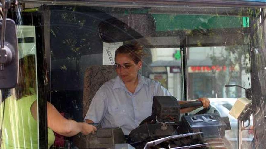 Una viajera presenta su tarjeta de viaje a una conductora de la EMT.