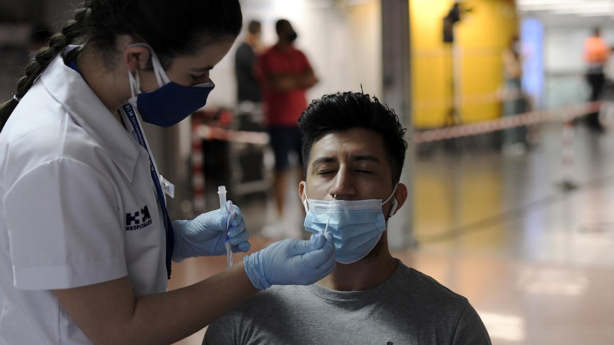 Una sanitaria realiza un test de antígenos a un hombre.