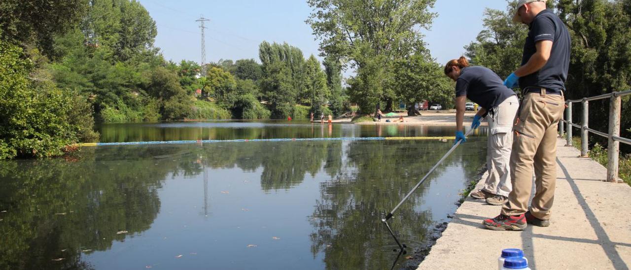 Técnicos de la Confederación Hidrográfica tomando muestras de agua, ayer en A Freixa.  |  // ANXO GUTIÉRREZ