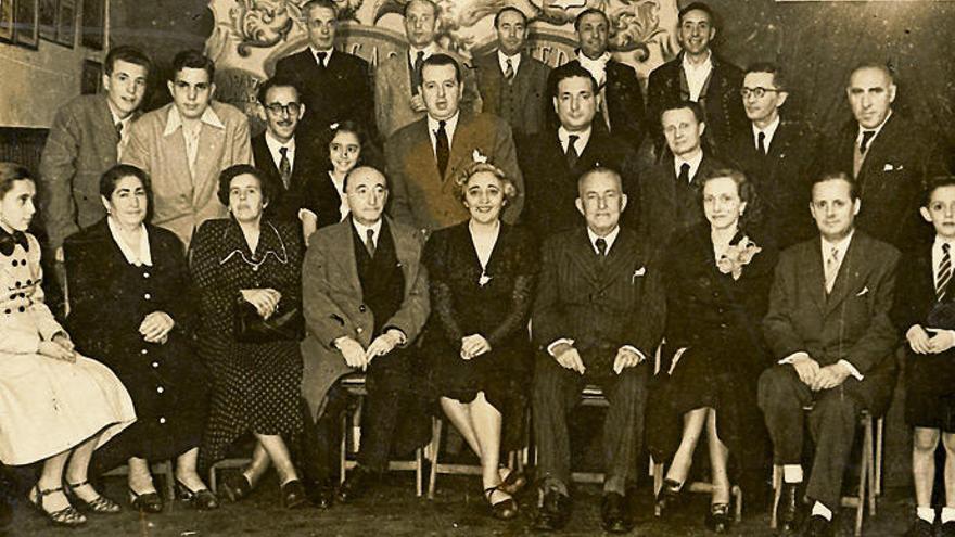 Visita de Wenceslao Fernández Flórez (sentado, cuarto por la izquierda) a Cántigas da Terra, en 1950. El presidente, José Luis Bugallal, Leandro Carré Alvarellos (segundo y primero por la derecha, de pie), otros miembros de la directiva, y el maestro Anta (quinto por la izquierda, de pie).