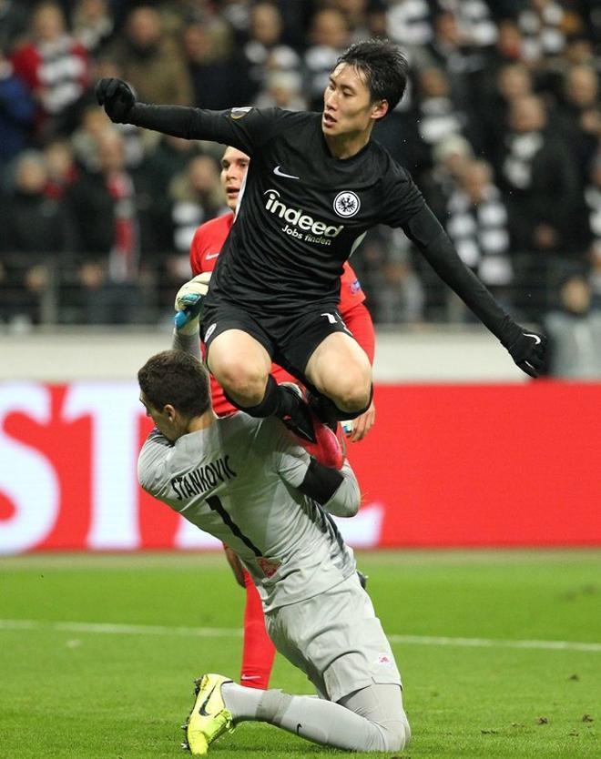 Daichi Kamada (top) del Frankfurt marca el 2-0 ante el portero del Salzburgo Cican Stankovic durante el partido de la entre el Eintracht Frankfurt y el Salzburg en Frankfurt am Main.