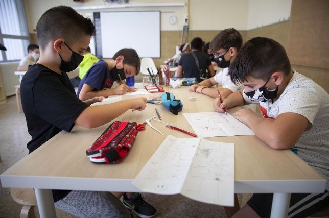 Unos estudiantes con mascarilla realizan tareas escolares, durante el curso 2020-21