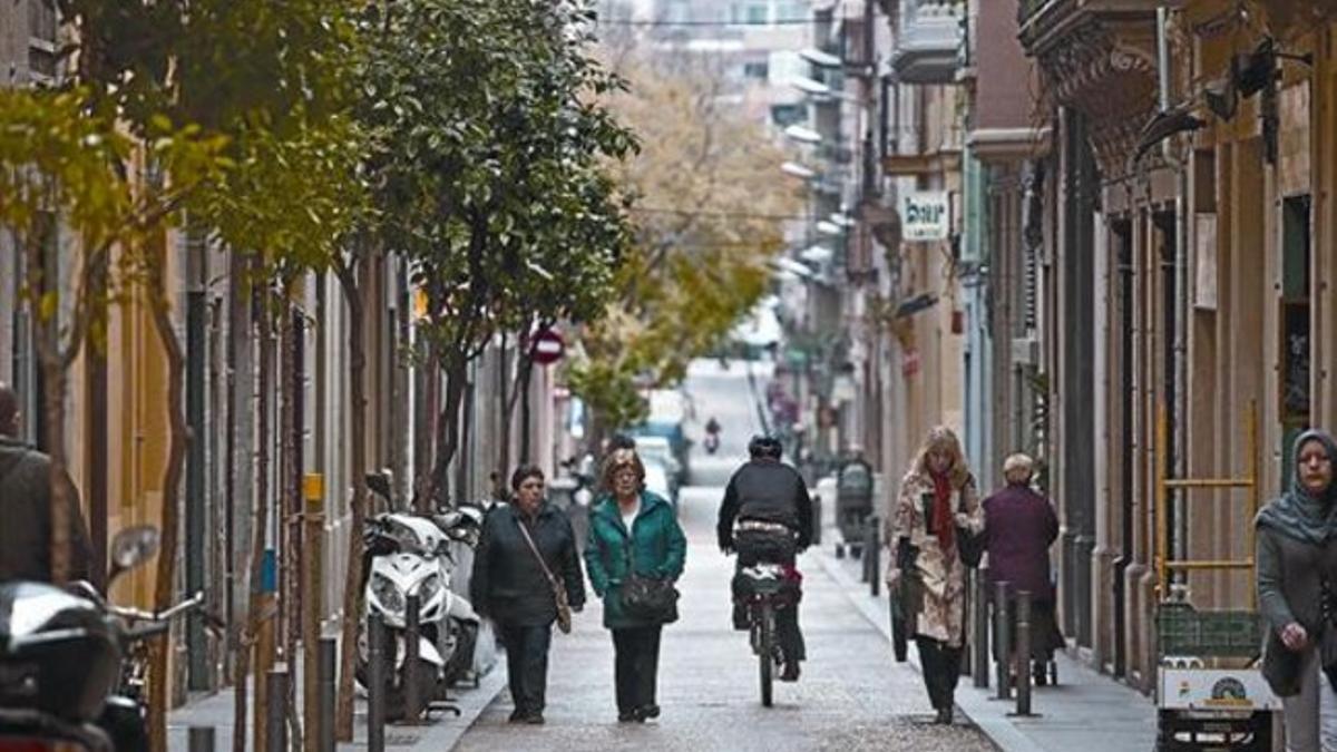 Peatones y un ciclista en la calle de Ramon i Cajal de la Vila de Gràcia, el viernes.