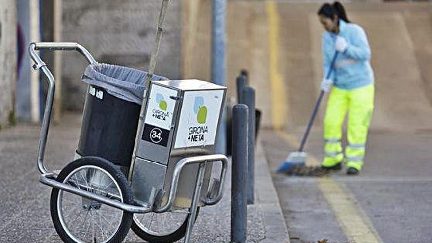 Una treballadora de Girona+Neta escombrant un carrer.