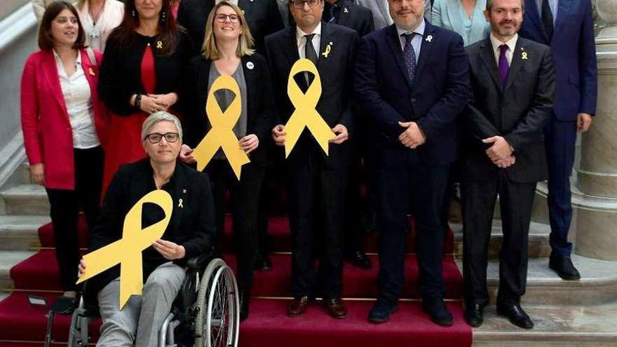 Torra (en el centro) y el resto de diputados de JxC posan con lazos amarillos tras la investidura. // AFP