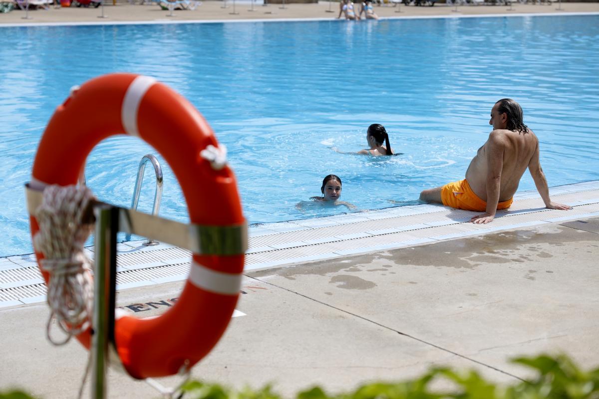 Familia disfruta en el agua durante el primer día de piscinas municipales