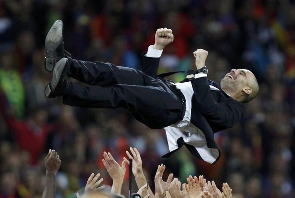 L’entrenador del Barça, Pep Guardiola, és mantejat pels seus jugadors després de guanyar la Lliga de Campions